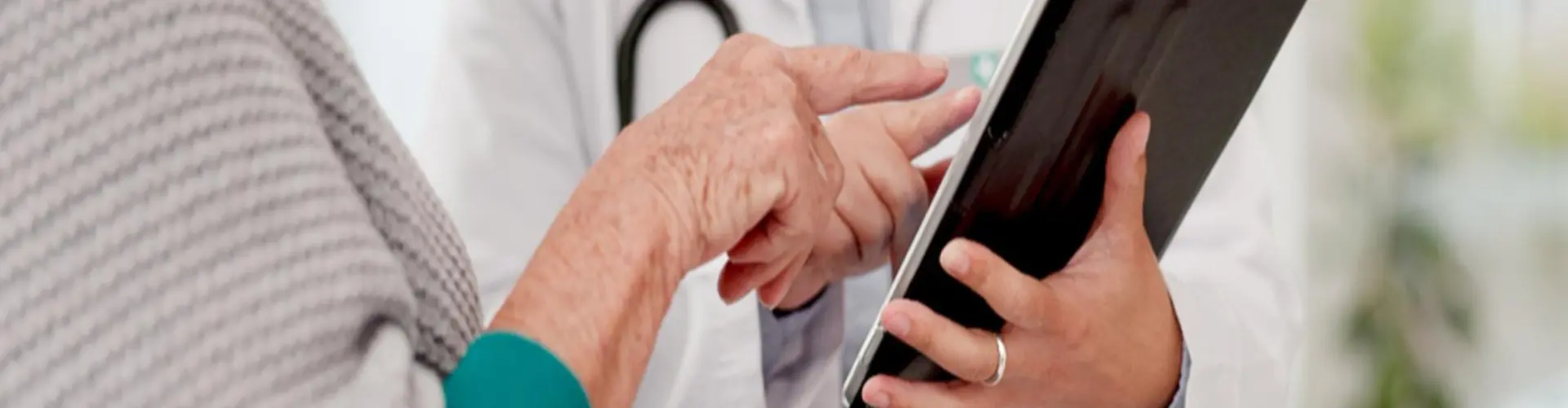 Nurse practitioner using digital healthcare technology while consulting with an elderly patient, illustrating the expanding role of nurse practitioners in modern healthcare.